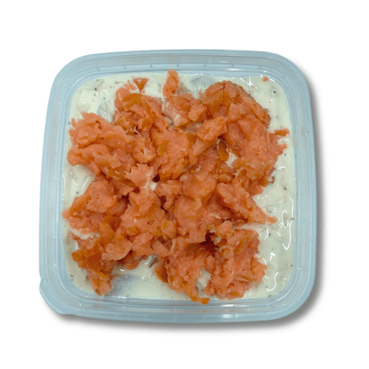 Creamy herring and lox spread in a bowl, served with crackers and fresh herbs on a white plate. Fishville seafood appetizer.