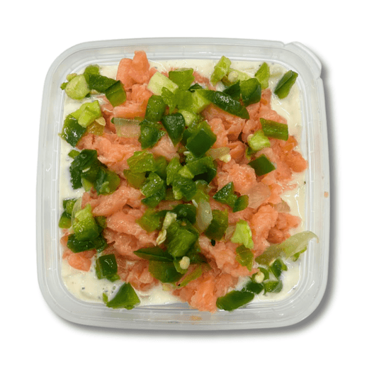Creamy herring and lox spread with jalapenos in a bowl, served with crackers on a wooden platter, by Fishville.